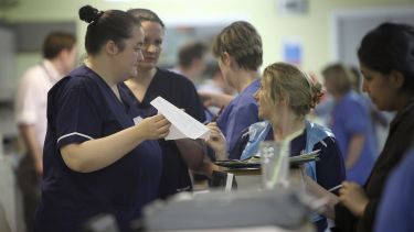 A group of nurses discussing medical information - images