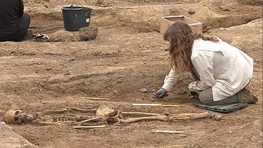 Student Emma Schlauder uncovering a skeleton at an archaeological dig site.