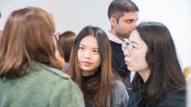 PhD students talking to a member of staff