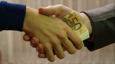 Money being transferred during a handshake