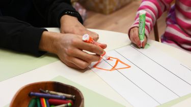 A teacher and child draw