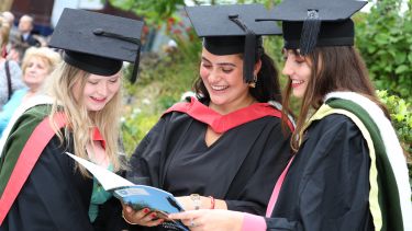 Graduands looking in programme