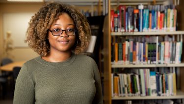 A ScHARR student in the library