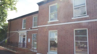 Barber House on a bright day. The windows and front door can be seen, as well as a sign above the door which says 'Barber House'.