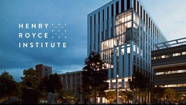 Twilight on a modern flagship research building, with lights glowing from within