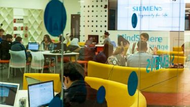 Students working in the MindSphere Lounge. The Siemens logo is very prominent. 