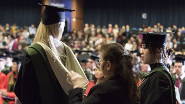 A female graduate's robe being sorted before she goes on stage.