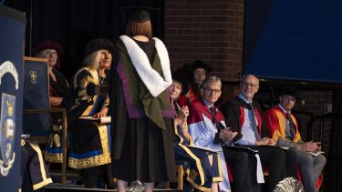 Graduand on stage shaking hands 