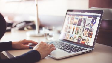 A person browses stock photos on a laptop.