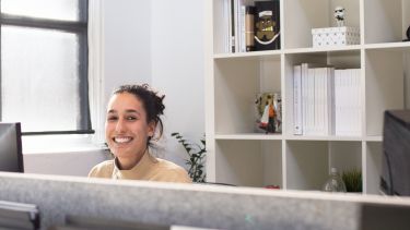 Image of a woman at her desk in an office