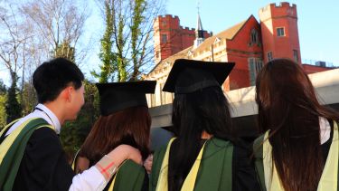 Four postgraduate taught students stood looking away from the camera 