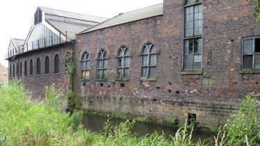 A photograph of a derelict mill behind the River Don. 