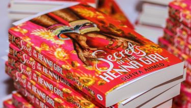 A stack of books called 'Secrets of the Henna Girl'