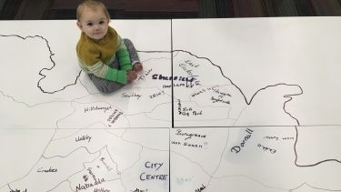 Photograph of young children on map of Sheffield