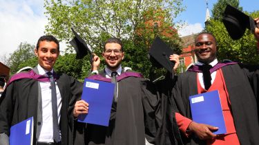 Three students who have just graduated with their certificates. 