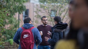 Three PhD students chatting outside
