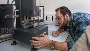 A researcher loads a sample into a rheometer