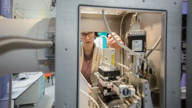 A researcher loads a sample into a SAXS instrument
