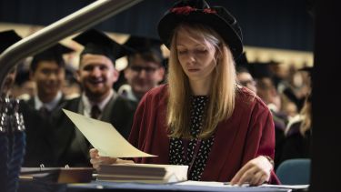 A staff marshal handing out certificates at the certificate desk
