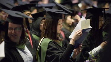 G student looking at certificate
