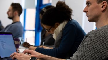 A student types notes in a lecture.