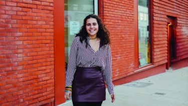 Student stands in front of an art gallery in the city centre
