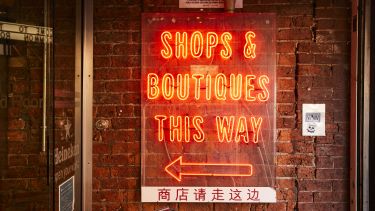 A neon sign advertises boutiques 