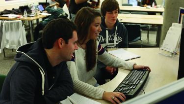 Economics students working on a computer