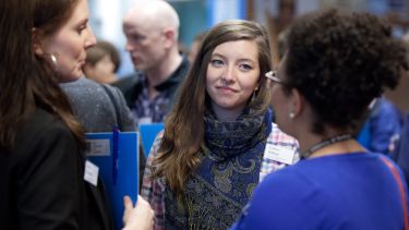 A student talking to alumni at a networking event