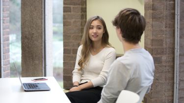 Two students talking in classroom