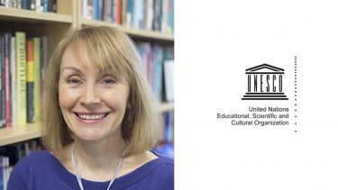 Professor Jackie Harrison in the library and the United Nations Educational, Scientific and Cultural Organisation logo. 