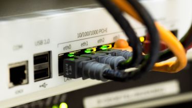 A photograph of cables sticking into the back of a router.