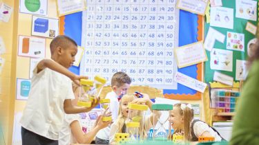 Children playing with hourglasses in a primary school maths lesson