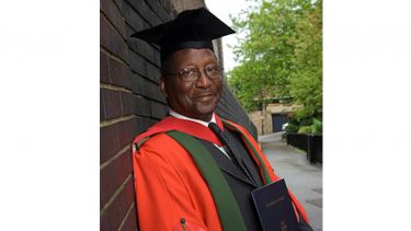 Dr Nicholas Liverpool in their graduation robes - image
