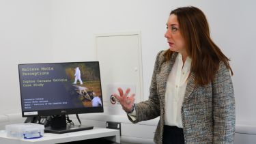 A postgraduate researcher giving a presentation on her research topic.
