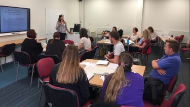 Lecturer presenting a slideshow to a classroom of students