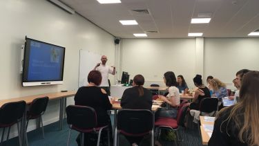 Lecturer presenting a slideshow to a classroom of students