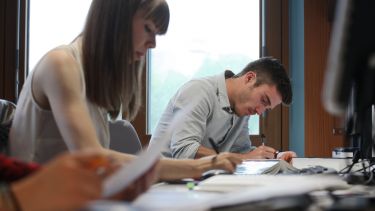Undergraduate students writing in a lecture