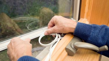 a pair of hands fits insulation to a window
