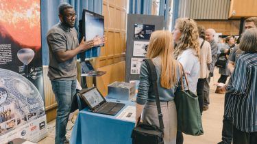 Man presents his research at stand