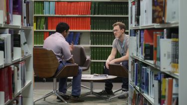 An image of seated students chatting in the Health Sciences Library.