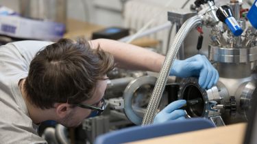 A technician operating equipment in a teaching lab