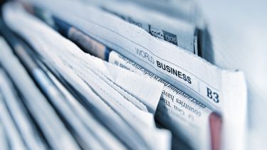 A collection of newspapers with the words world business in focus