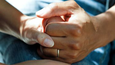 Two hands holding each other