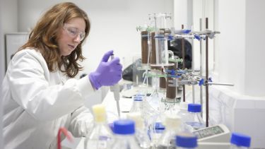 A woman in a lab coat conducts an experiment
