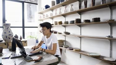 Small business owner using computer inside store