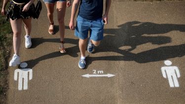 Young people walking on a street with social distancing markers