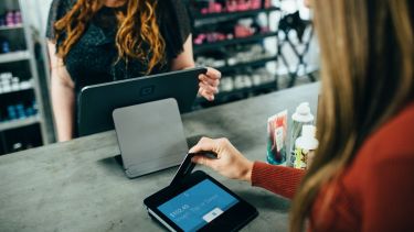 A customer paying for a purchase in a shop using a debit card.