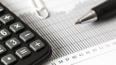 Calculator, paper, paperclip and pen