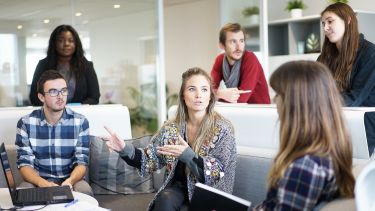 A manager having a meeting with her staff in an office environment